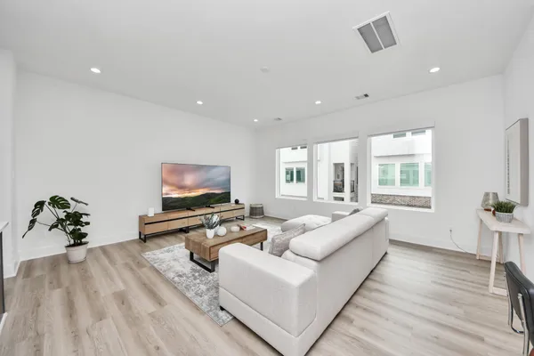 a living room with furniture wooden floor and a flat screen tv