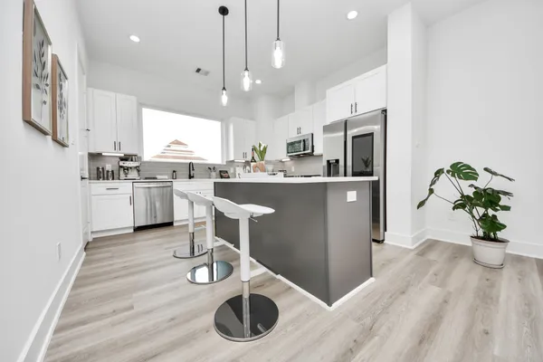 a kitchen with stainless steel appliances kitchen island granite countertop a stove a sink and a refrigerator