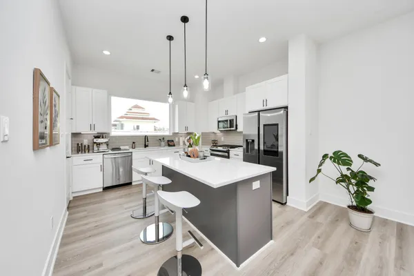 a kitchen with white cabinets and refrigerator