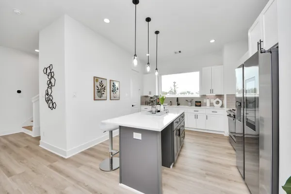 a kitchen with stainless steel appliances kitchen island a sink cabinets and wooden floor