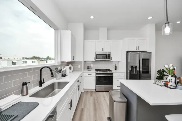 a kitchen with refrigerator a sink and a stove