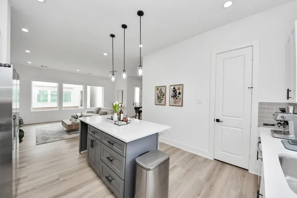 a view of a kitchen counter space a sink wooden floor and a window