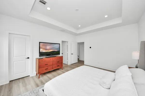 a bedroom with a bed and wooden floor