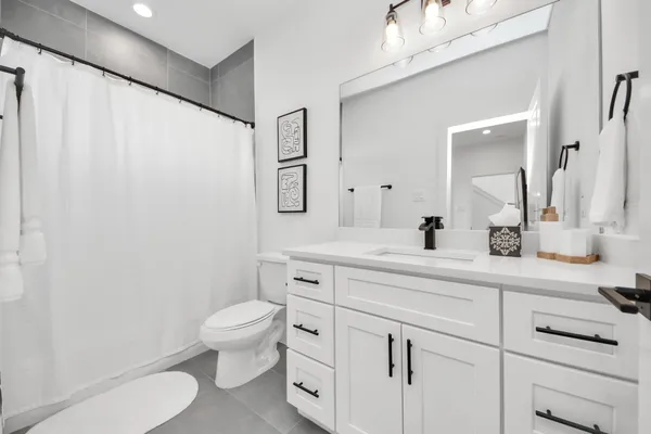 a spacious bathroom with a toilet sink and a mirror
