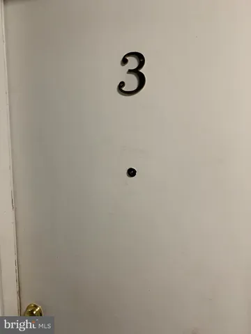 an empty room with wooden floor and a bathroom