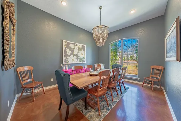 a view of a dining room with furniture a chandelier and wooden floor