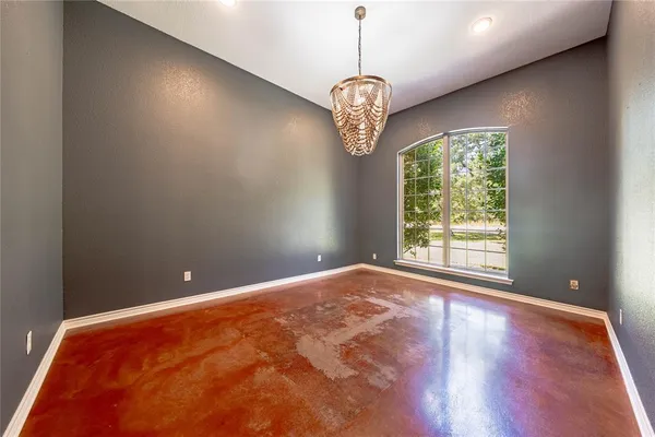a view of an empty room with a window and chandelier