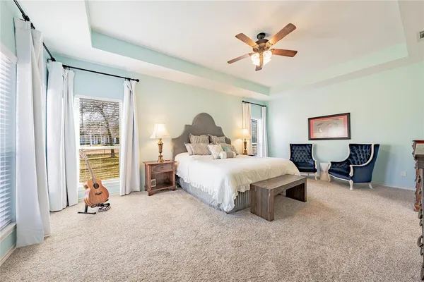 a spacious bedroom with a bed and a chandelier