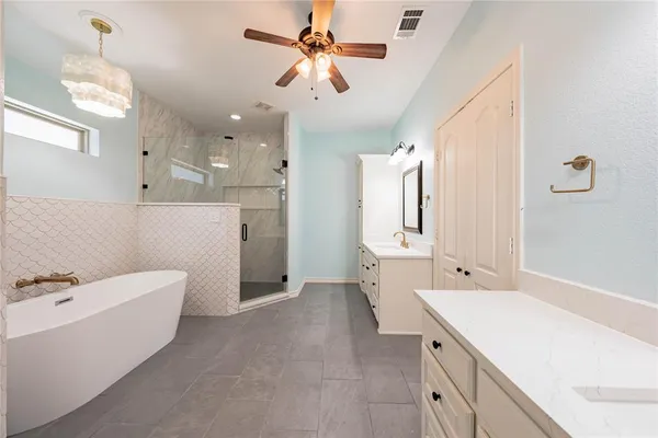 a bathroom with a double vanity sink a mirror a bathtub and