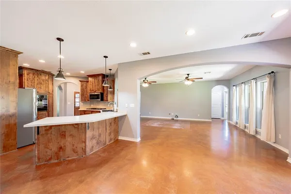 a large kitchen with stainless steel appliances a large counter top