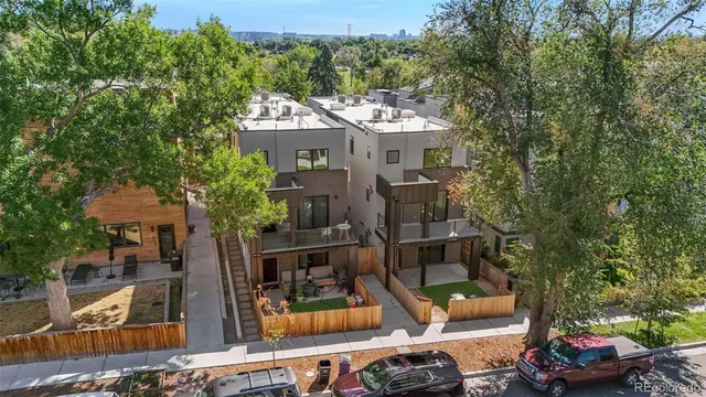 a front view of a house with a garden and trees