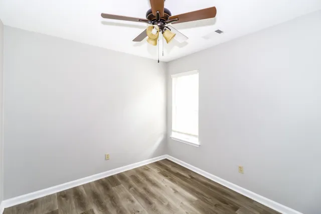 a room with a window and a chandelier fan