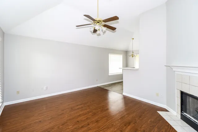 an empty room with wooden floor and window