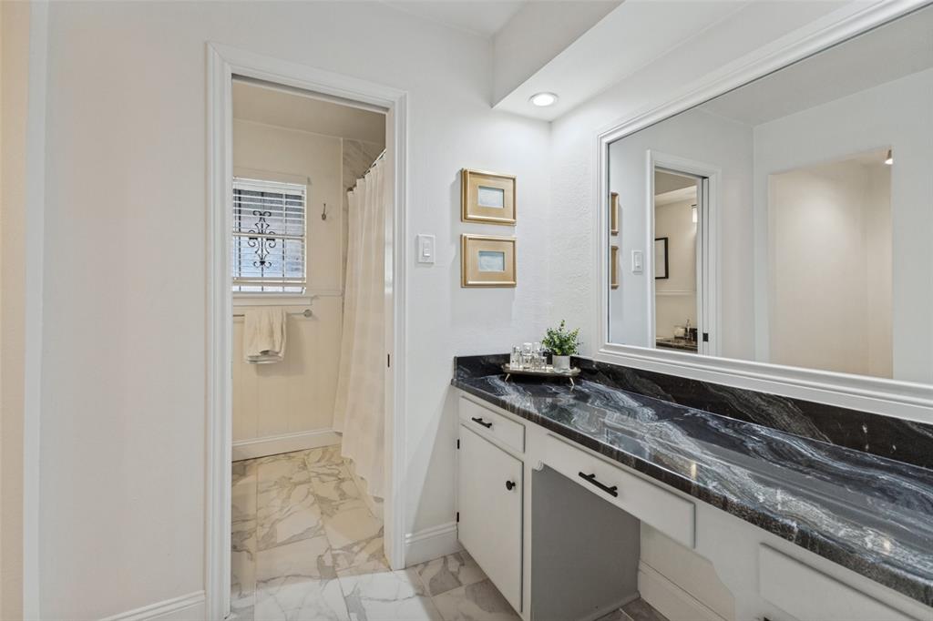 9864 Shoreview Road Dallas, TX 75238 - Photo 18 of 24 White cabinetry with dark hardware and a black patterned countertop