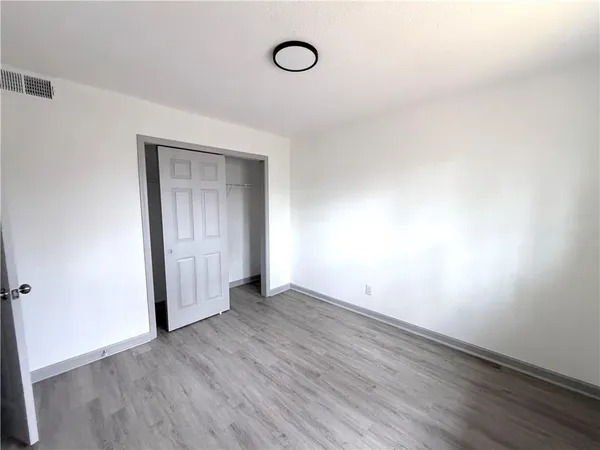 an empty room with wooden floor and window