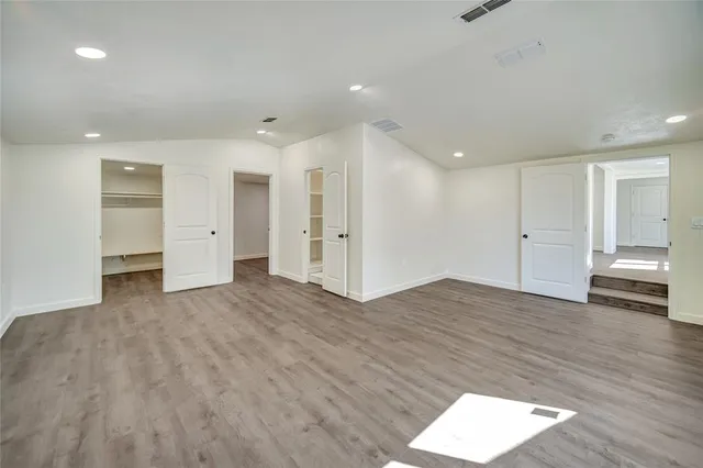 a view of empty room with wooden floor