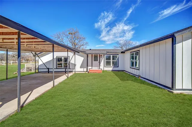 a view of a house with backyard and porch