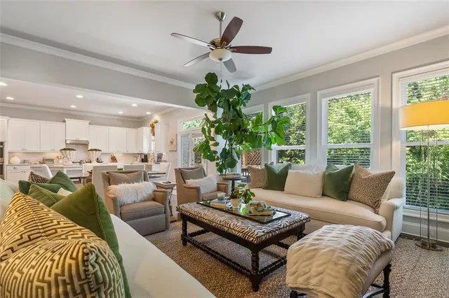 a living room with furniture kitchen view and a large window