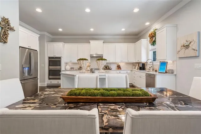 a living room with stainless steel appliances furniture and a table