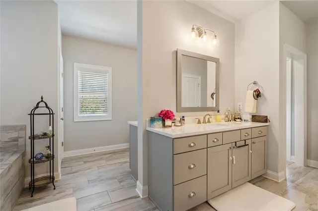 a bathroom with a double vanity sink mirror and next to a window