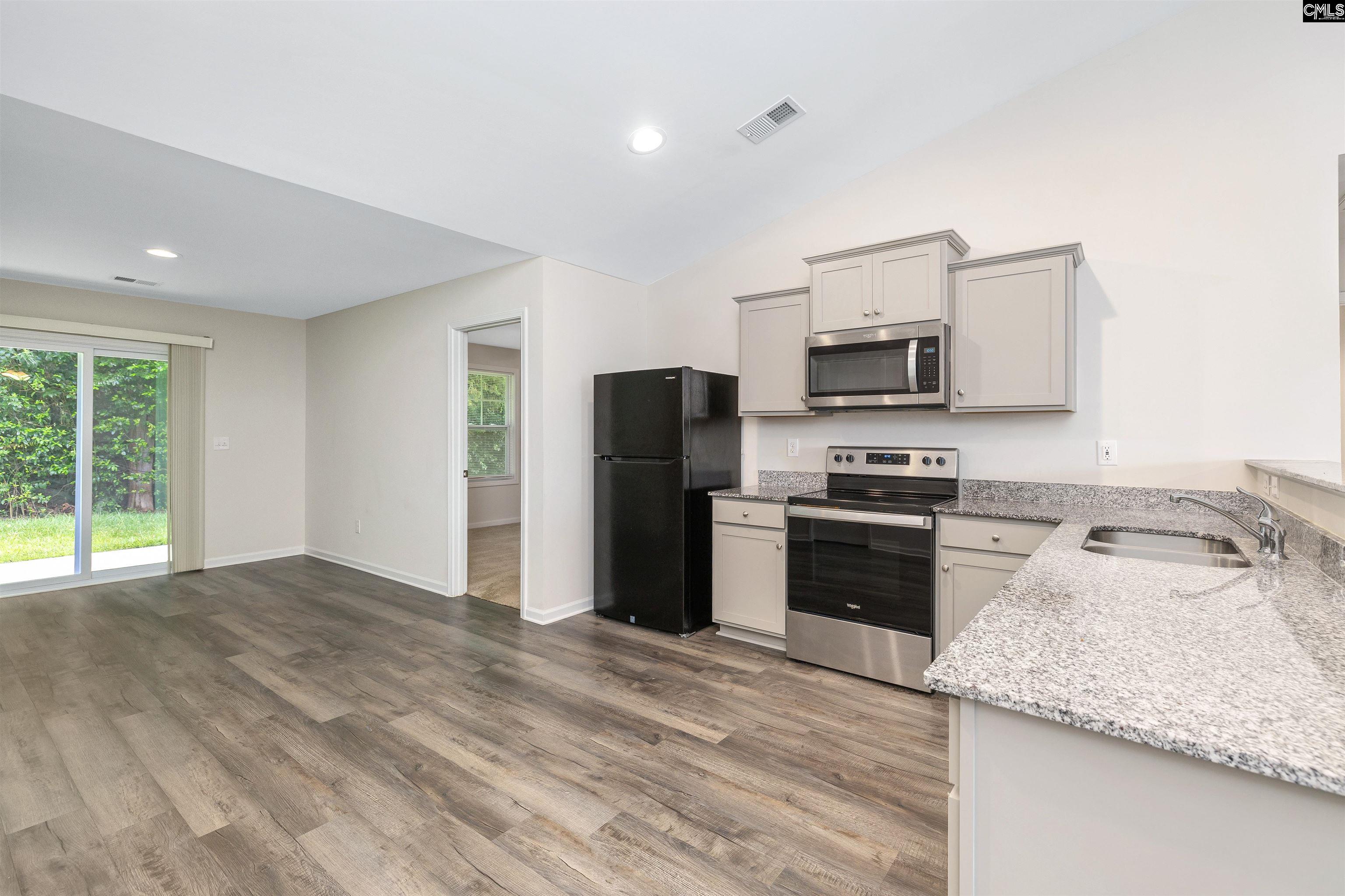 2157 Still Pointe Drive Sumter, SC 29154 - Photo 11 of 25 a kitchen with granite countertop a refrigerator stove and microwave