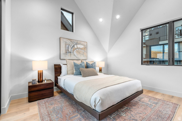 1258 Rothwell Road Park City, UT 84060 - Photo 13 of 48 Vaulted ceiling bedroom featuring light wood-finish flooring, a large black-framed window, a small upper accent window, and recessed lighting