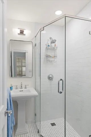 a bathroom with a shower sink and mirror
