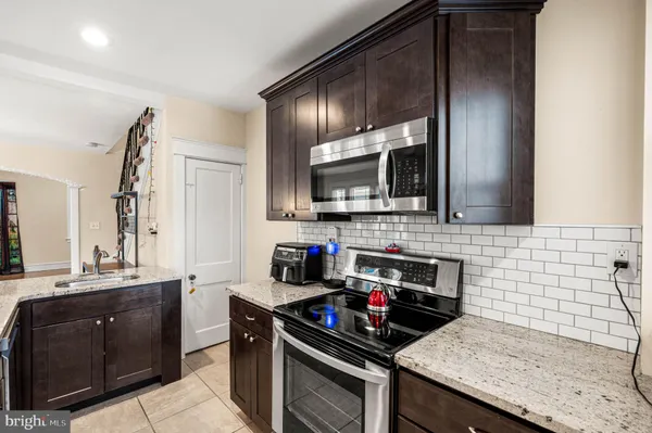 a kitchen with a sink and a stove top oven with wooden floor