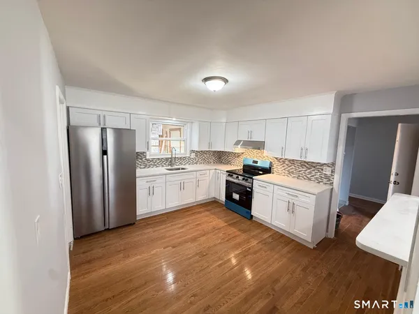 a kitchen with stainless steel appliances granite countertop a refrigerator sink and cabinets
