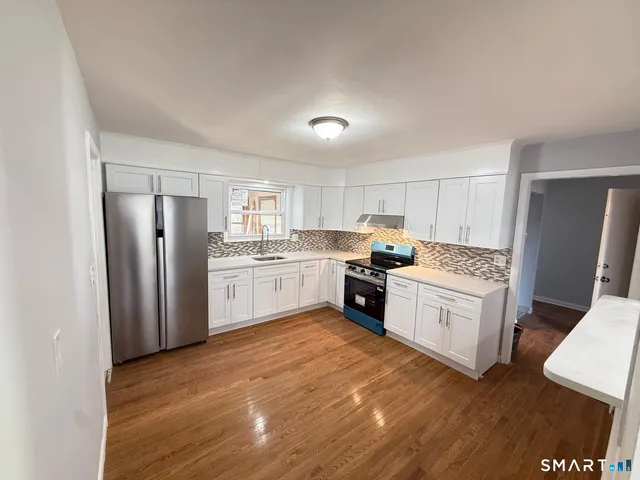 a kitchen with stainless steel appliances granite countertop a refrigerator sink and cabinets