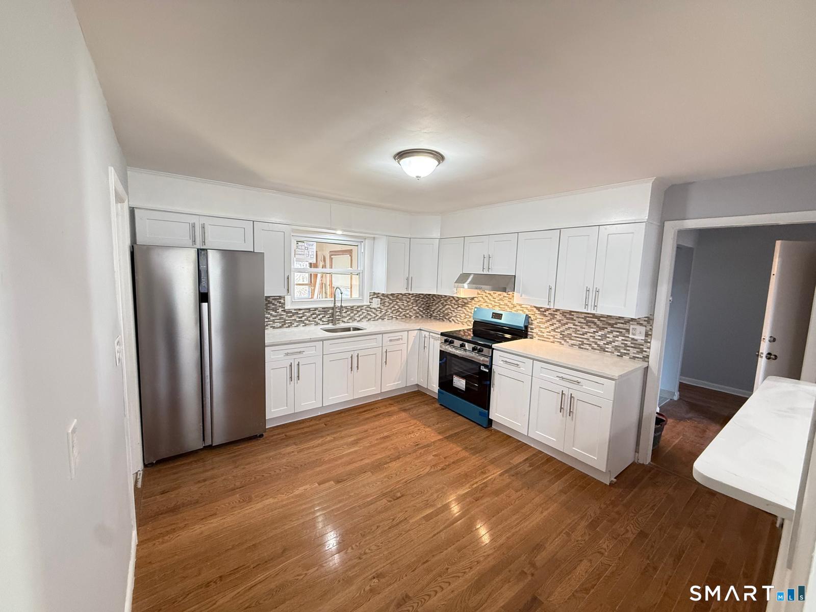 a kitchen with stainless steel appliances granite countertop a refrigerator sink and cabinets