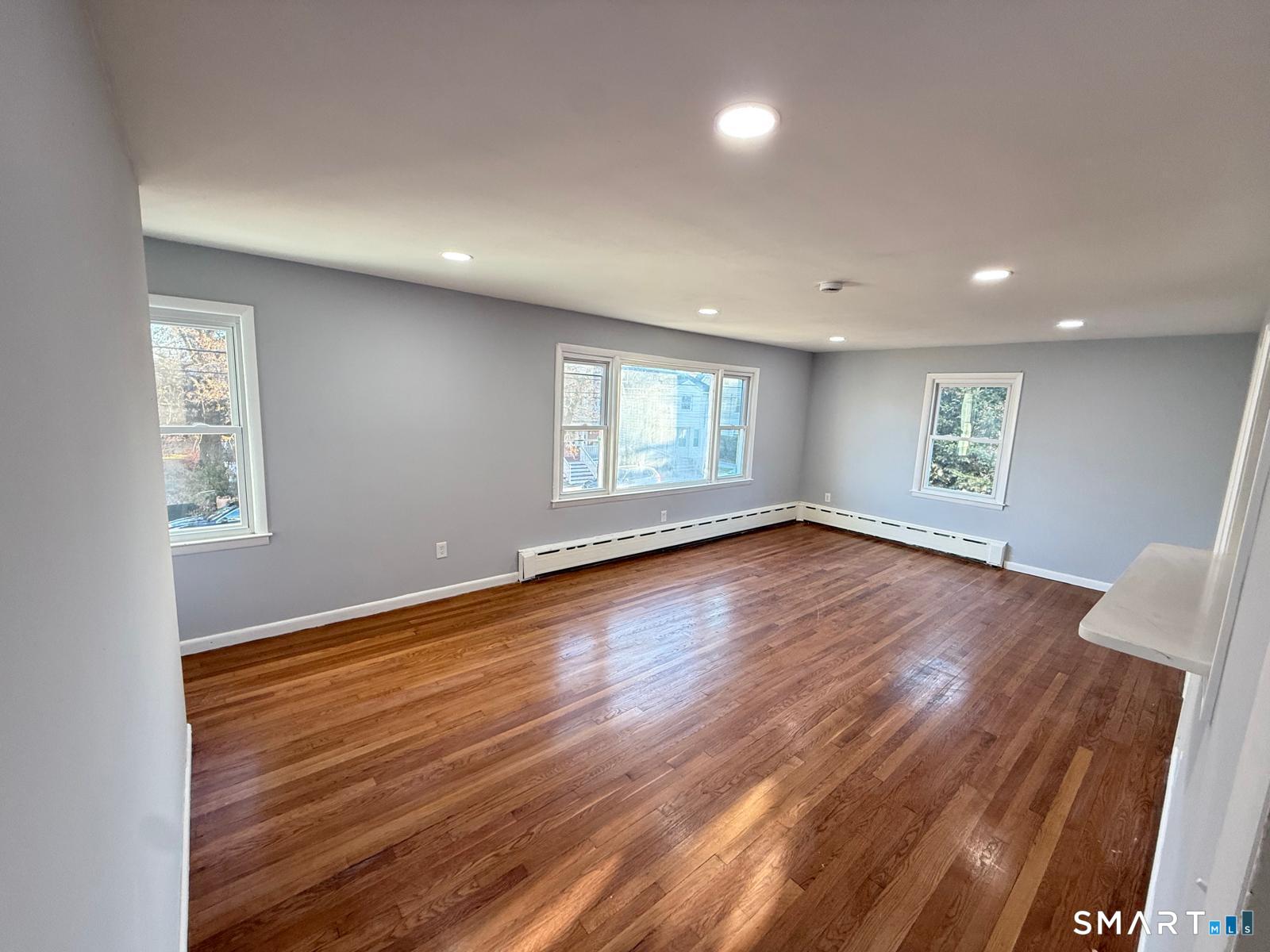 524 Garfield Avenue, Unit 2 Bridgeport, CT 06606 - Photo 2 of 10 a view of empty room with window and wooden floor