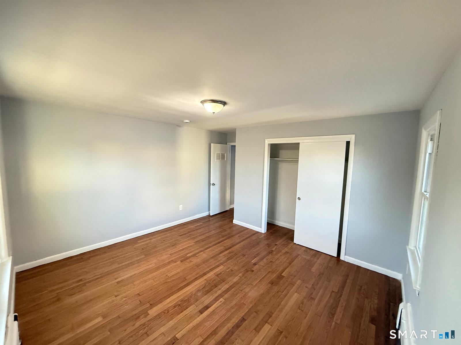524 Garfield Avenue, Unit 2 Bridgeport, CT 06606 - Photo 5 of 10 a view of an empty room with wooden floor and closet