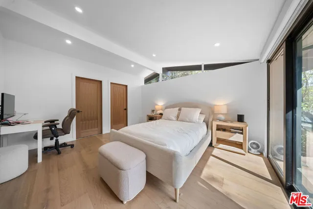 a bedroom with a large bed and a large window