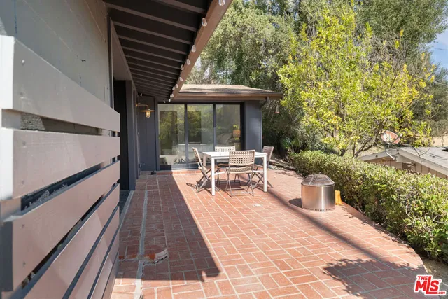 a view of a patio with table and chairs potted plants with wooden floor