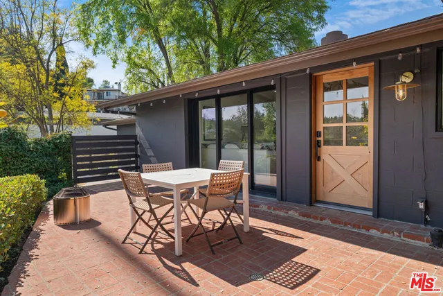 a view of a patio with table and chairs with wooden floor and fence