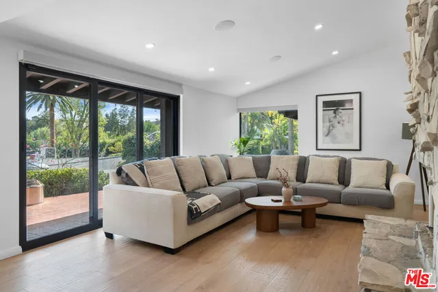 a living room with furniture a flat screen tv and a floor to ceiling window