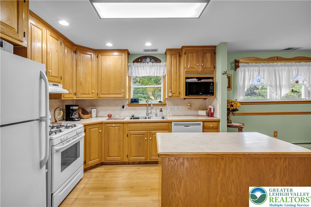 2750 Belaire Road Bethlehem, PA 18017 - Photo 18 of 56 Warm oak cabinetry and a central island ground this light-filled culinary space.