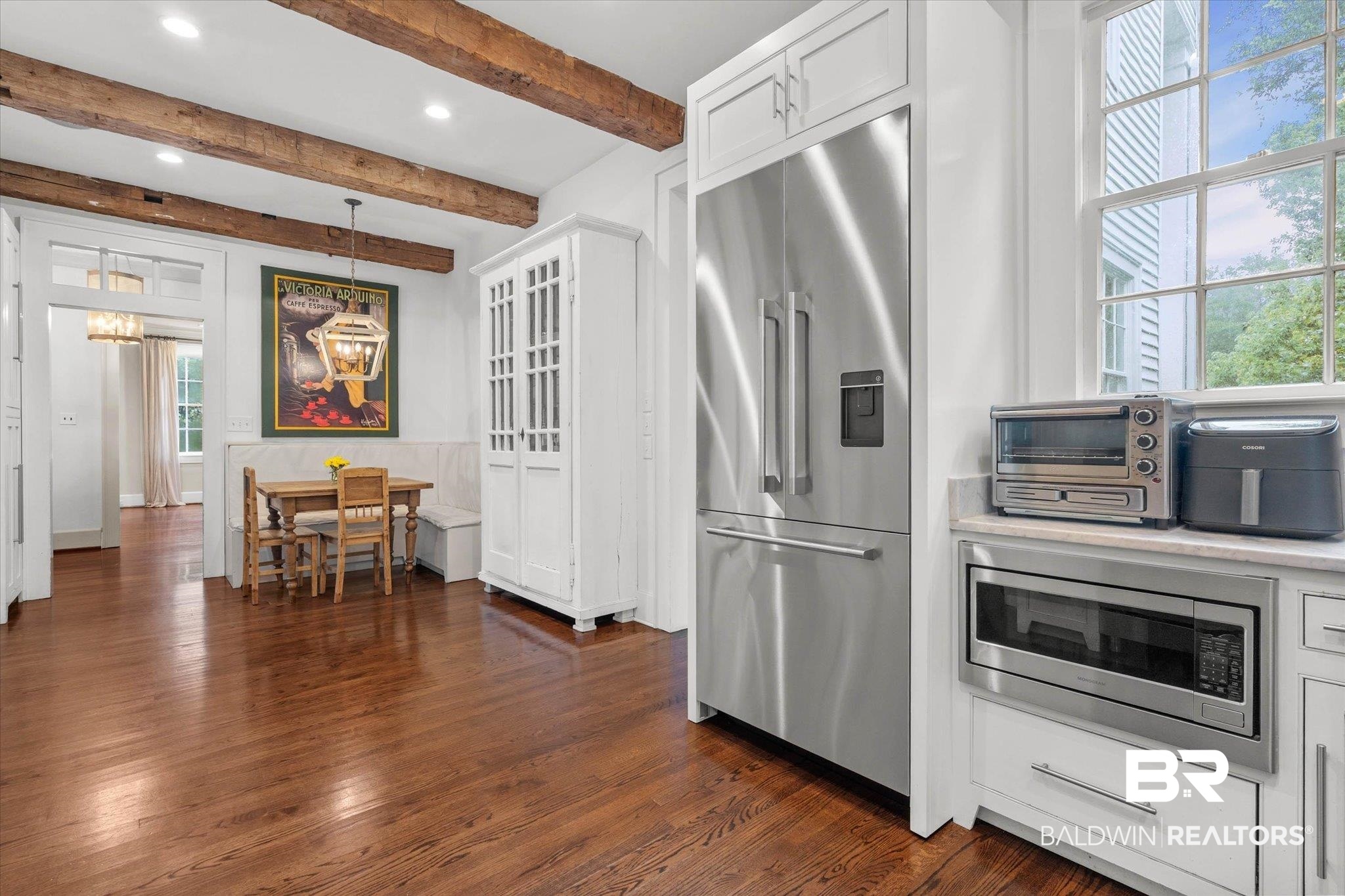 3863 Old Shell Road Mobile, AL 36608 - Photo 10 of 48 Kitchen featuring exposed wood beams, hardwood flooring, built-in stainless steel refrigerator, white cabinetry, and a built-in microwave