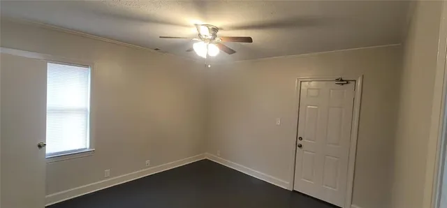 an empty room with windows and fan