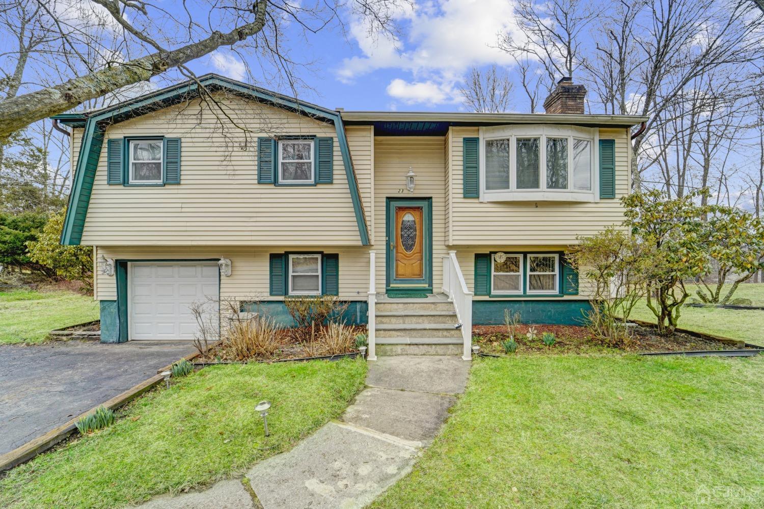 a front view of a house with a garden and yard