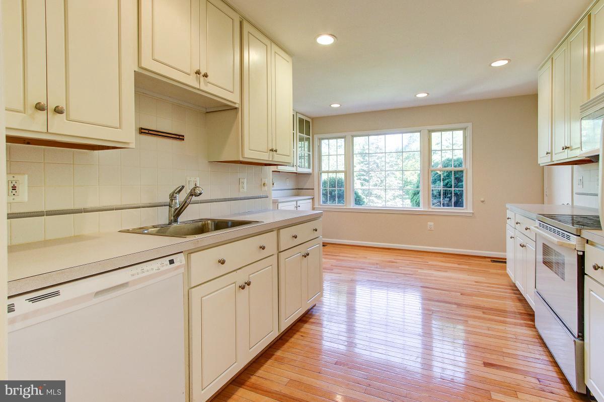 12301 Coleraine Court Reston, VA 20191 - Photo 8 of 29 a kitchen with granite countertop white cabinets and a wooden floor