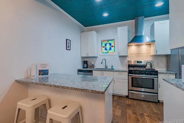 a kitchen with stainless steel appliances granite countertop a stove a sink and a microwave