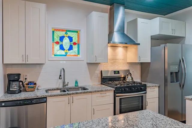 a kitchen with stainless steel appliances a stove a sink and a refrigerator
