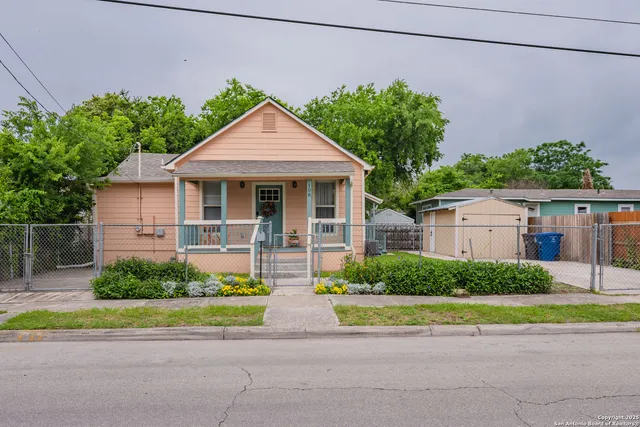 a front view of a house with a yard and potted plants