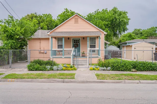 a front view of a house with a yard and potted plants