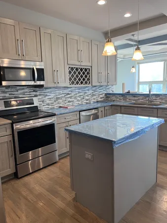 a living room with stainless steel appliances kitchen island granite countertop furniture and a fireplace