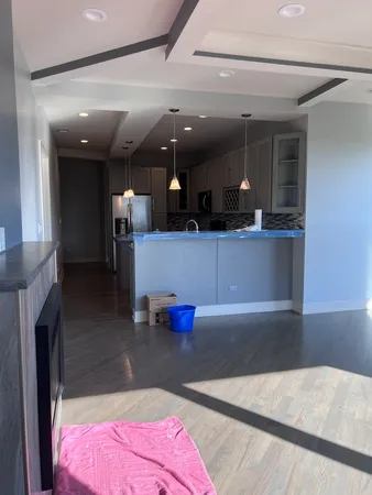 an empty room with floor to ceiling window and fireplace