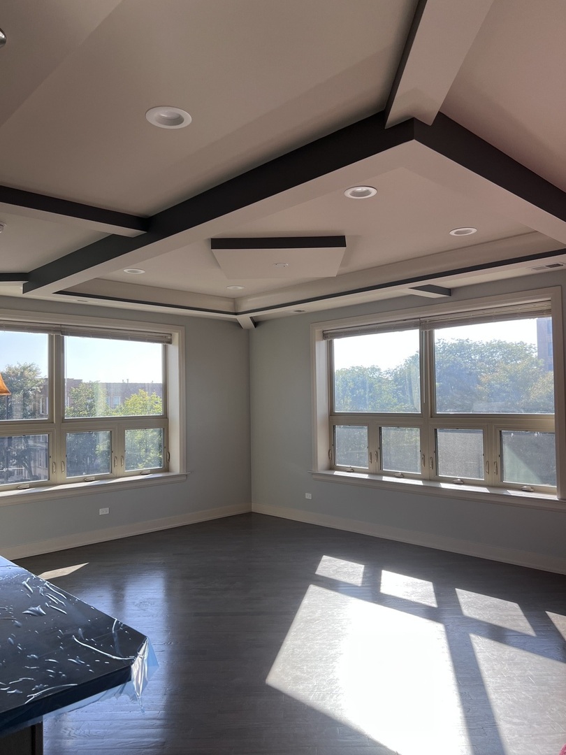 1208 East 64th Street, Unit 2B Chicago, IL 60637 - Photo 8 of 19 a view of an empty room with wooden floor and a window