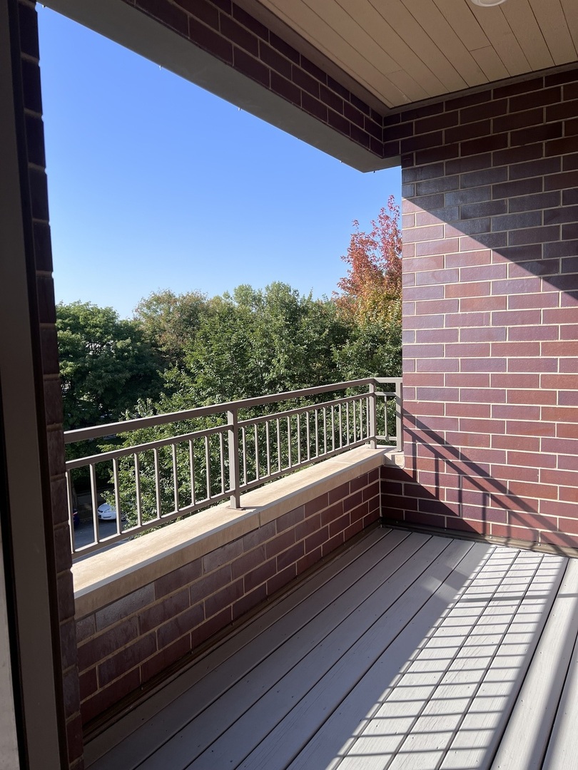 1208 East 64th Street, Unit 2B Chicago, IL 60637 - Photo 10 of 19 a view of balcony with wooden floor and fence